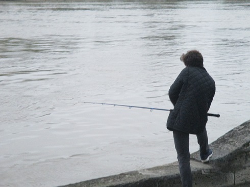 増水したセーヌで釣りをする人