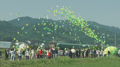 風船で運転再開を祝う人々