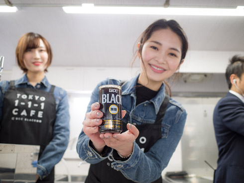 コーヒーを持った女性店員の写真