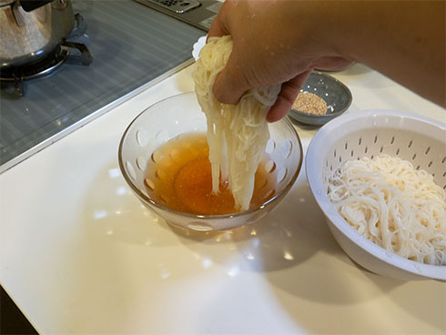 そうめんをスープに入れるところ