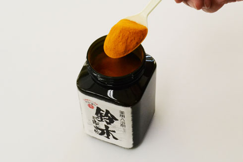 「薬用入浴剤　鈴木」の中身をすくう様子