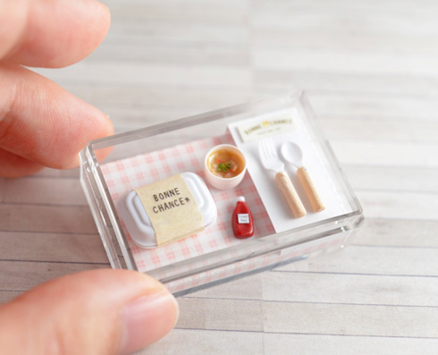 ミニチュア弁当箱セットを指で押さえている様子