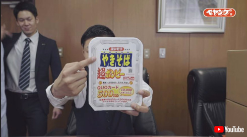 ヨシモリブランドの焼きそばを掲げるヨシモリ