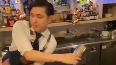 シェーカーとグラスでジャグリングするバーテンダー