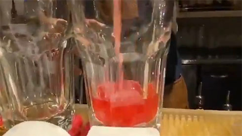 赤いカクテルが注がれるところ