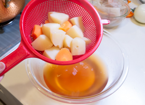 ゆで汁をザルにあけるところ