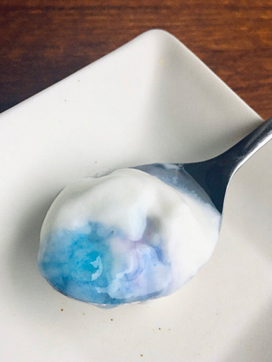 オーロラのようなヨーグルトをスプーンですくったところ