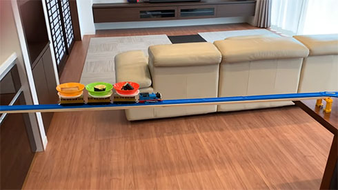 キッチンとテーブルに架けられた橋を渡るトーマス