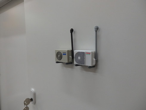 壁面型室外機カプセルトイをロッカーに張った様子