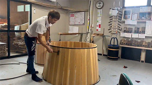 たがを左側から金槌で叩いている様子