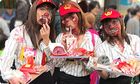 ファストフードを食べるゾンビに仮装した人