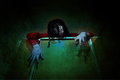 トイレのうえから幽霊が顔を出しているところ