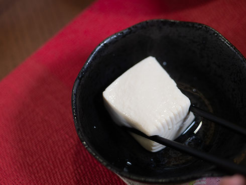 四角い湯豆腐を箸で挟むところ