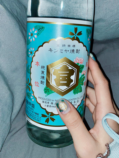 焼酎ネイルをして焼酎を持っている