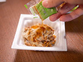 生姜焼納豆にタレを入れるところ