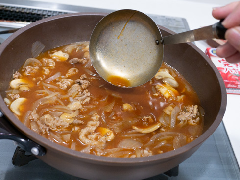 ハヤシライスのとろみをおたまで確認している様子