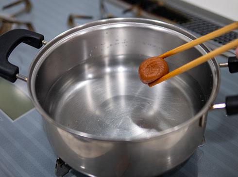 梅干しを鍋に入れるところ