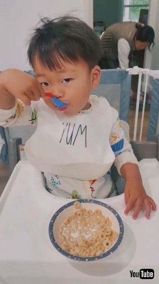 「Toddler Spills Milk on the Floor While Trying to Pour it Into Bowl of Cereal - 1202181」