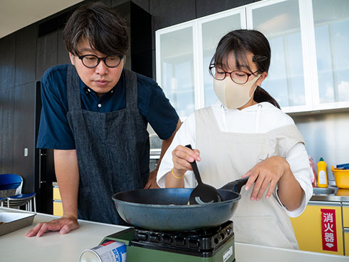 玉ねぎを炒めるスズちゃんをのぞき込むパパ