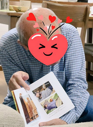 麦くんに写真集を見せるお父さん・お父さんトリミング