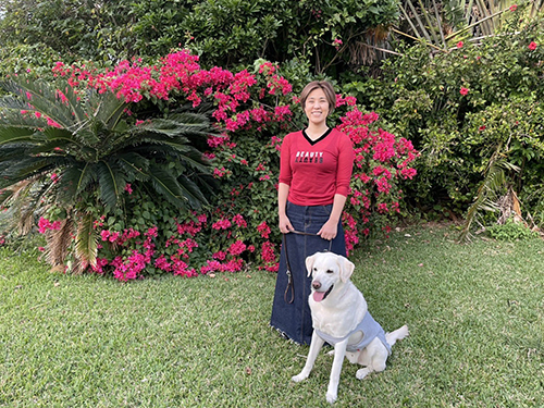 お花を前にした浅井さんとヴィヴィッドくん 盲導犬 レストラン 待機場所 全盲者