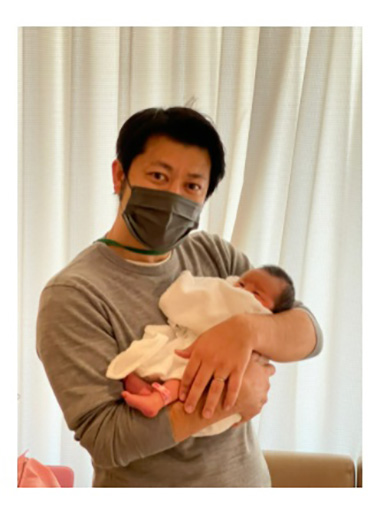 子どもを抱いて緊張気味の夫