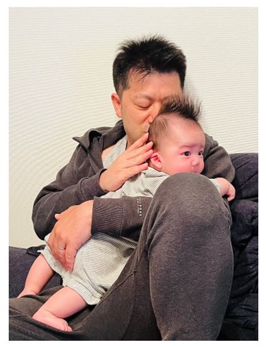 息子を抱っこするだいたひかるの夫