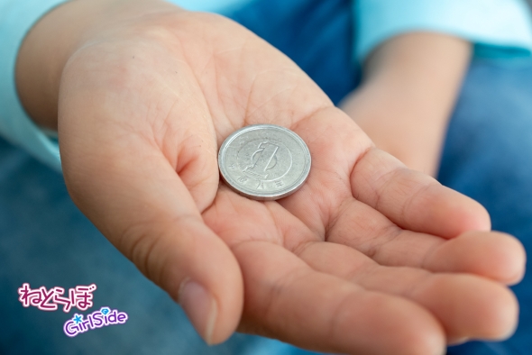 1円玉を持つ子どもの画像