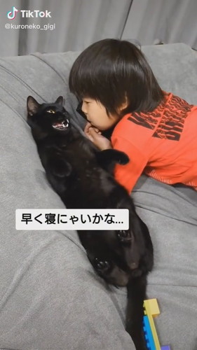 猫「早く寝にゃいかな〜」 子どもを寝かしつける黒猫