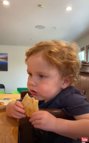 ピザを食べながらウトウトする男の子