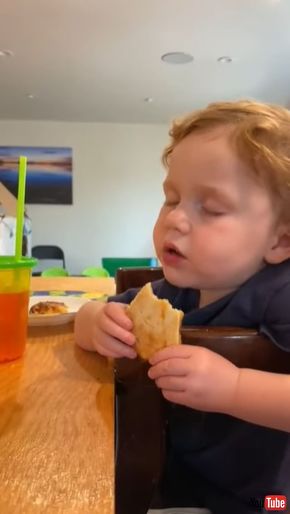 ピザを食べながらウトウトする男の子