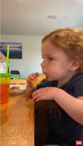 ピザを食べながらウトウトする男の子