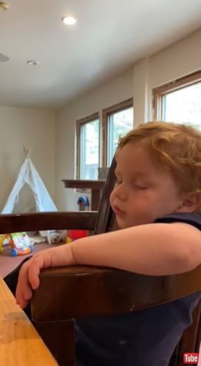 ピザを食べながらウトウトする男の子