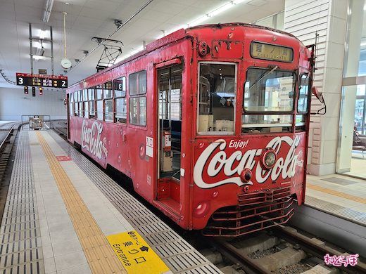 セピア色の世界を走る「コカ・コーラ」ラッピングの電車