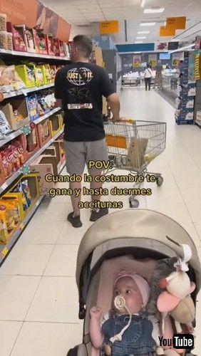 誰も乗っていないカートを優しく揺らすパパ