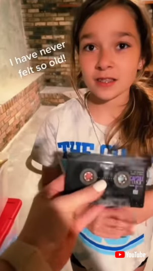 カセットテープを見つめる娘