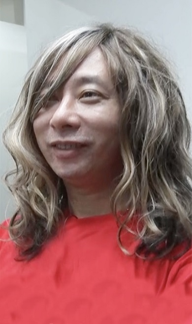 ウエーブがかった長髪のかつらを着用したいしだ壱成