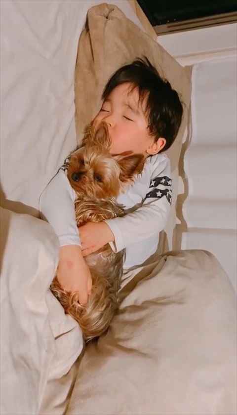 ワンコを抱きしめて寝る息子さん