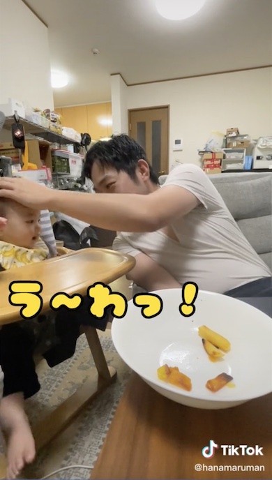 お父さんのまねをしてしゃべる赤ちゃんの写真