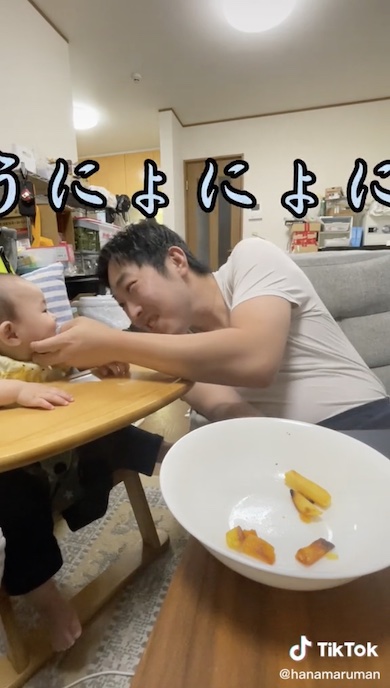 赤ちゃんをあやす父の写真