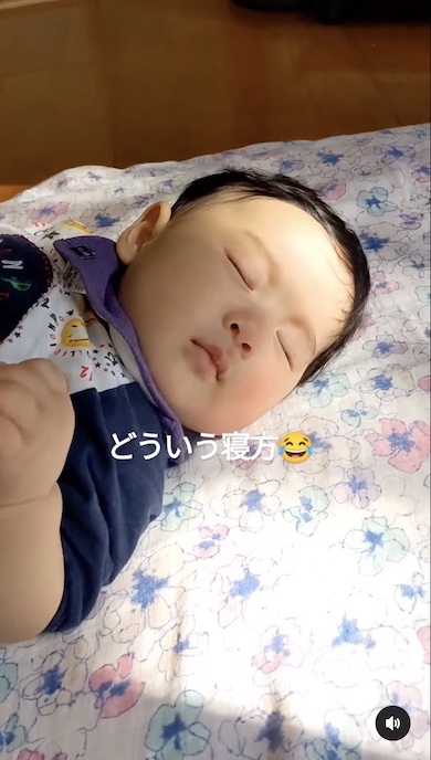 独特な寝相で寝る赤ちゃんの顔の写真
