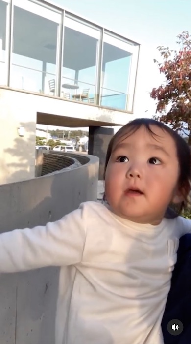 窓の向こうのママを見上げる女の子の写真