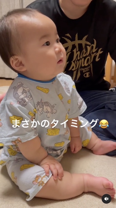 赤ちゃんをゲップさせようと背中をトントンするパパの写真