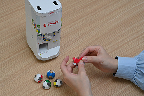 ガシャポン自販機を再現した「ガシャポンペーパークラフト」発売　ハンドル操作で紙製カプセルが飛び出す本格仕様