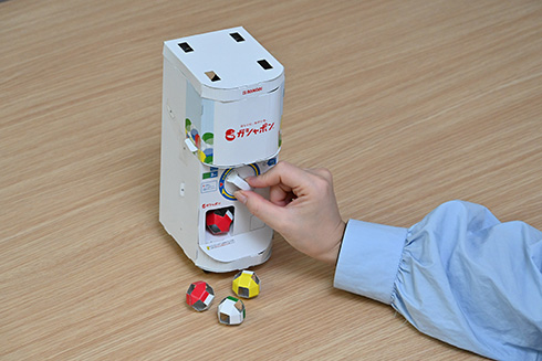 ガシャポン自販機を再現した「ガシャポンペーパークラフト」発売　ハンドル操作で紙製カプセルが飛び出す本格仕様