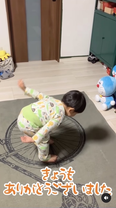 本やおもちゃに一礼する男の子の写真