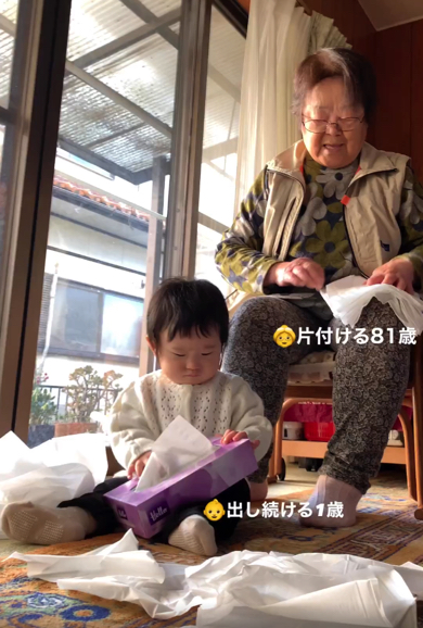 ティッシュで遊ぶ赤ちゃんを見守るひいおばあちゃん