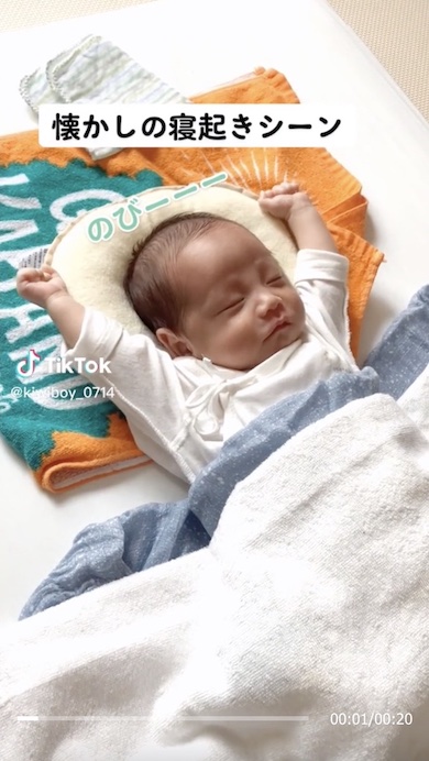 寝起きに大きく伸びをする赤ちゃんの写真