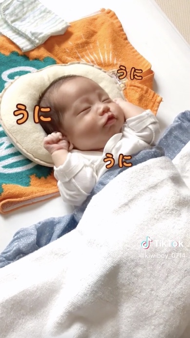 寝起きに体をくねくねさせる赤ちゃんの写真