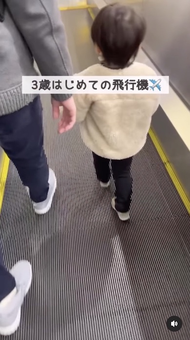 空港のエスカレーターを歩く3歳男の子の写真